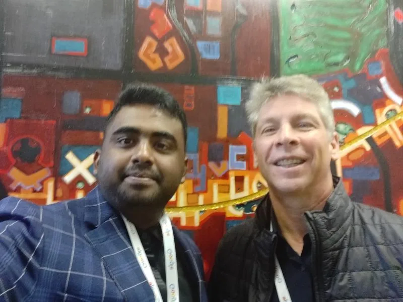 Selfie with a man in front of a colorful mural