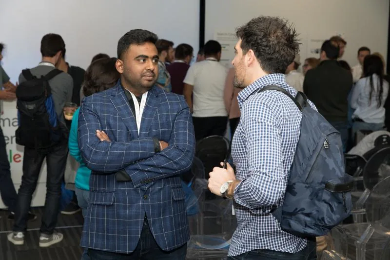 Venkata standing and chatting in a crowded conference hall