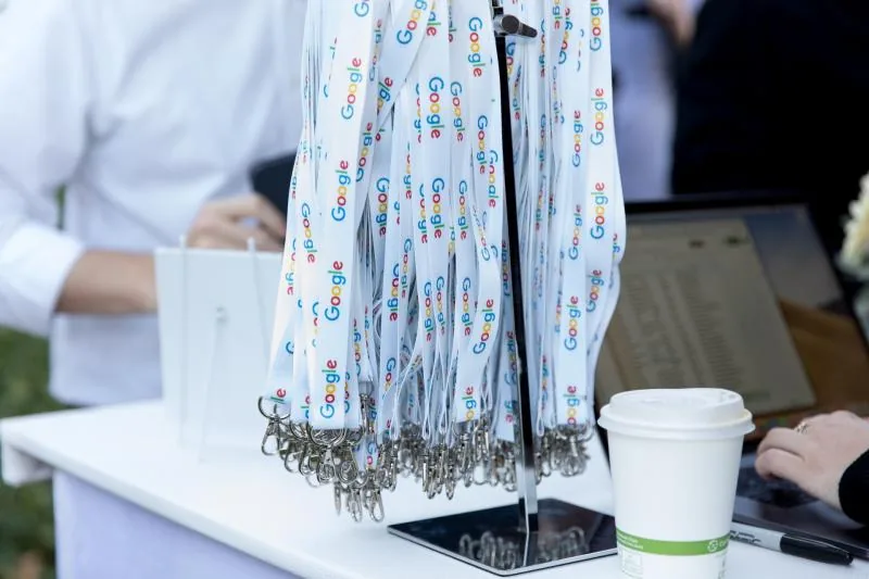 Google lanyards and coffee cup on a registration table