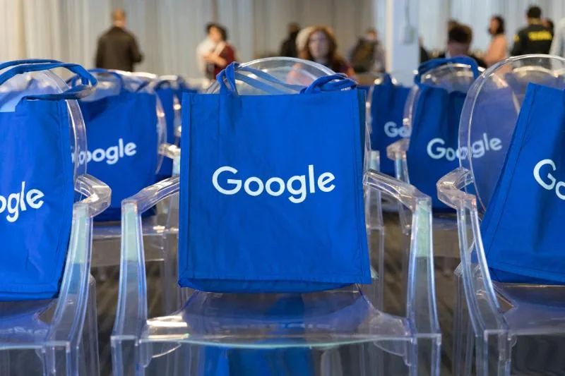 Blue Google tote bags placed on conference chairs