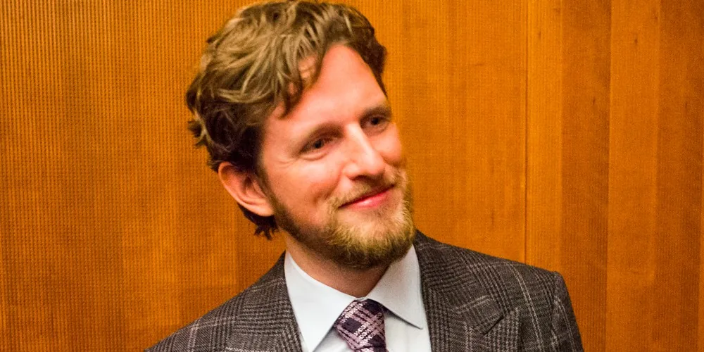 Smiling bearded man in suit and tie, no caption