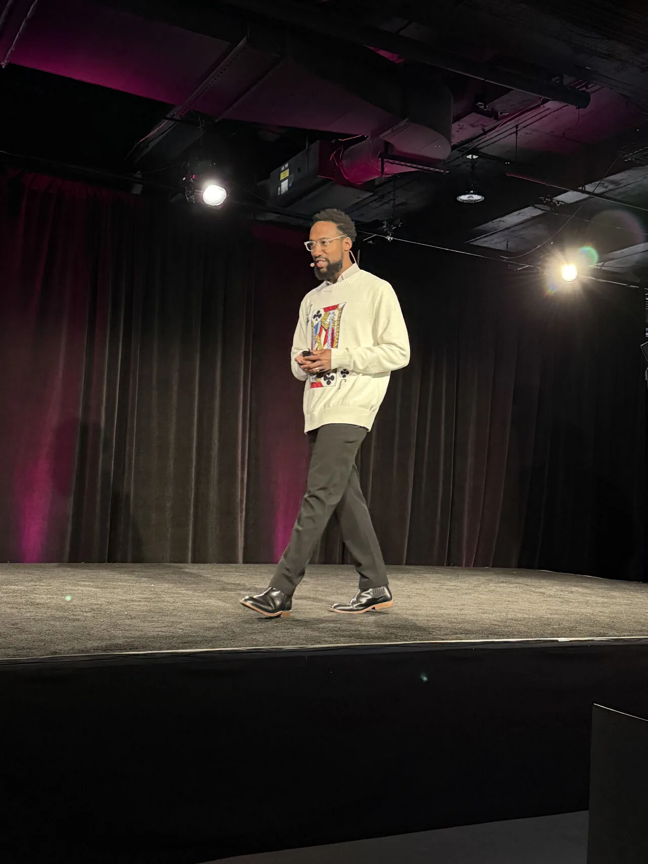 Speaker walking across a dark conference stage