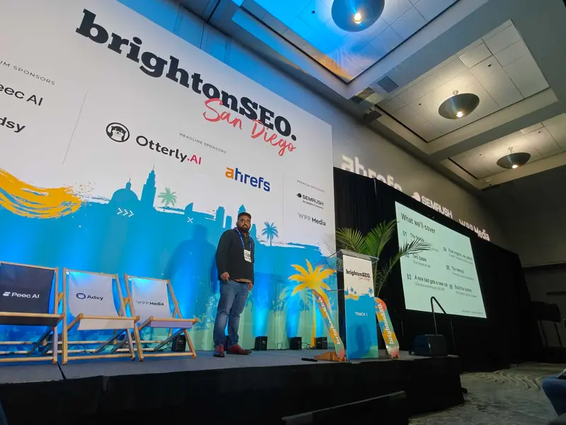 Venkata Pagadala on stage at brightonSEO San Diego 2026 beside the agenda slide: the thesis, two cases, a new dad gets a new car, four engines and one pattern, the method, and building the system