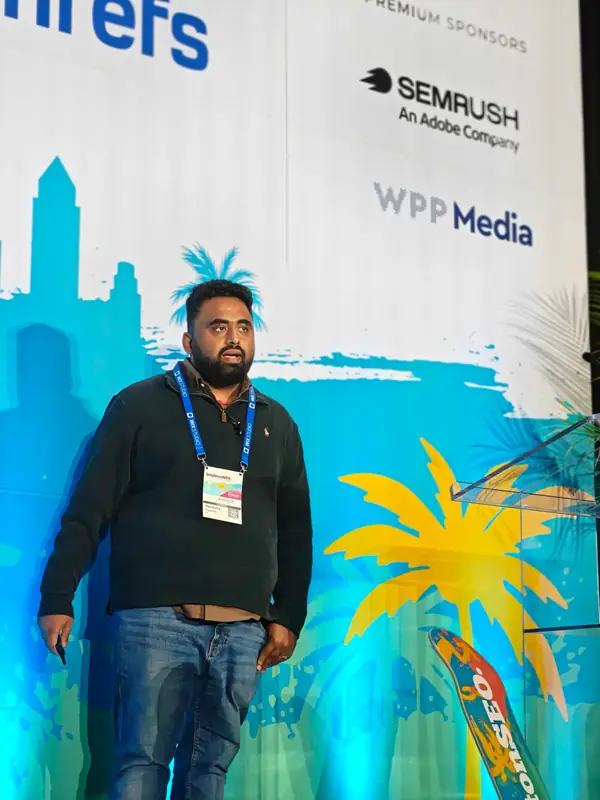 Close view of Venkata Pagadala speaking at brightonSEO San Diego 2026, wearing his speaker badge
